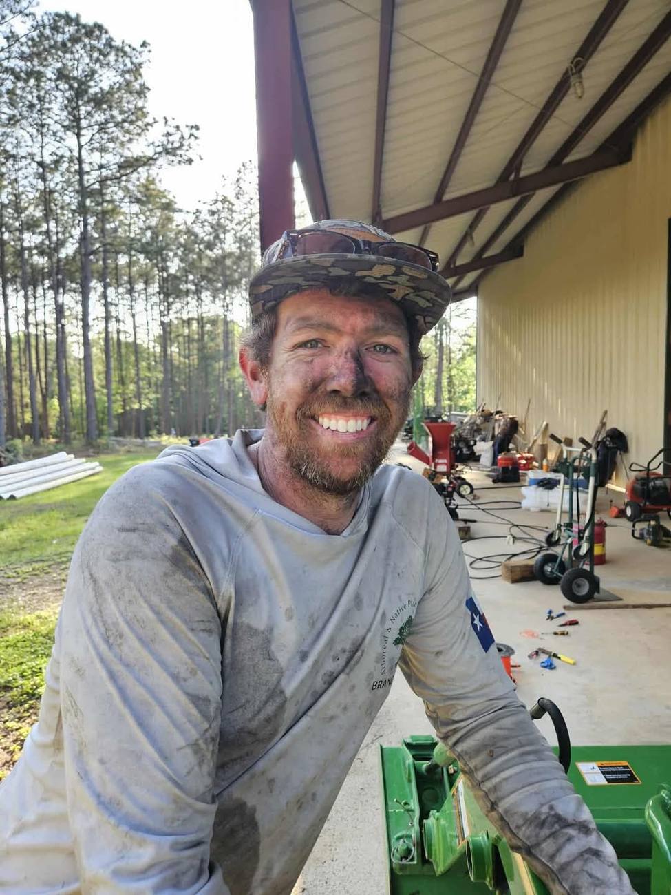 A crew member covered in sawdust and dirt, smiling at the end of a working day