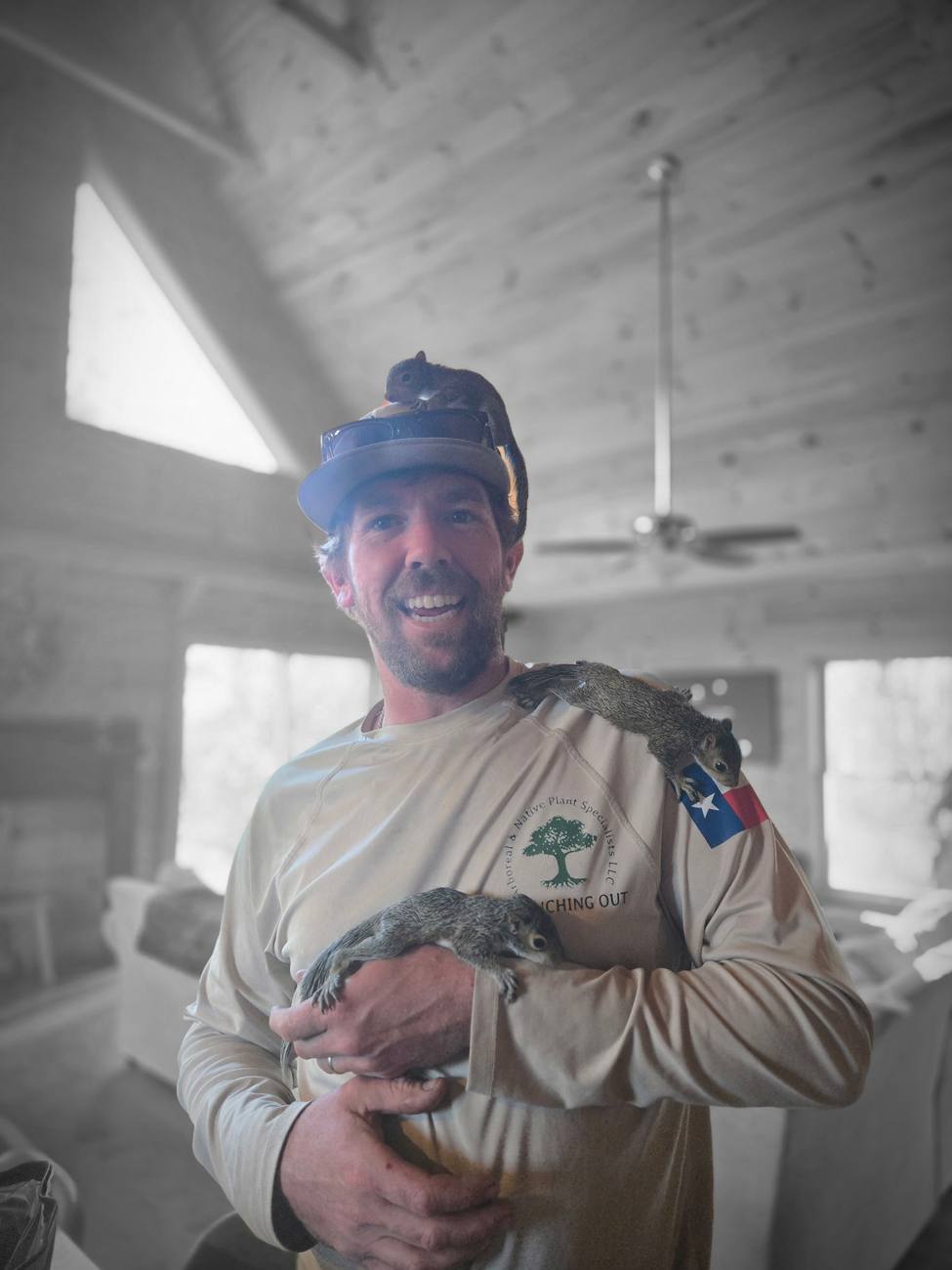 A crew member holding several young squirrels